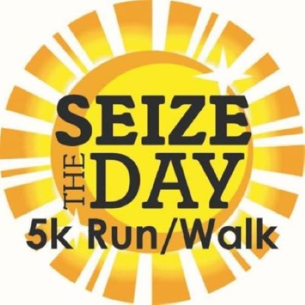 Logo for the Seize the Day 5k Run/Walk, featuring a bright yellow sunburst and bold black text saying 'SEIZE THE DAY' with '5k Run/Walk' beneath.