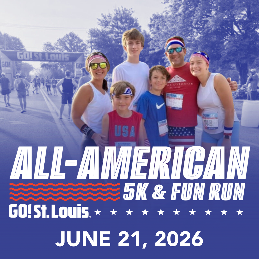 Group of runners posing together at a race event with a banner reading 'All-American 5K & Fun Run' and 'GO! St. Louis' in the background, June 21, 2026.