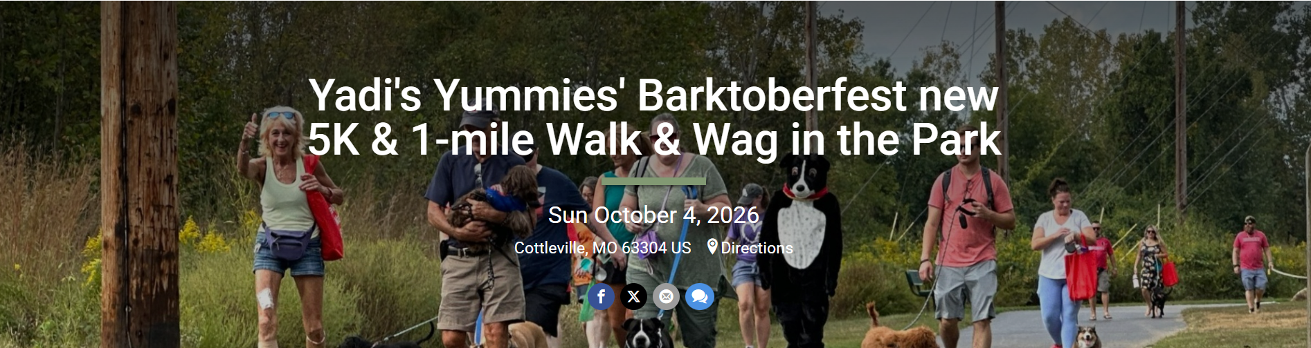 Crowd walking dogs in a park during a charity Barktoberfest event, with volunteers and dogs on leashes amid trees and a sunny day.